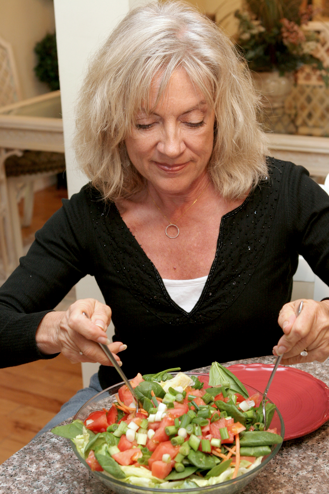 mature woman eating a salad.jpg